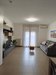 a large living room with a couch and a tv at My Home Apartments in Matera