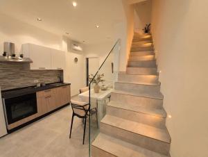 a staircase in a kitchen with a table and a chair at A casuzza in Modica