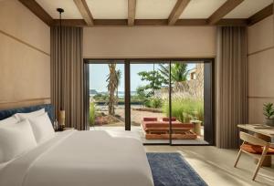 a bedroom with a bed and a sliding glass door at Six Senses AMAALA in Amala +35 photos