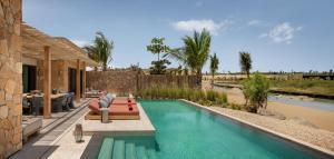 a swimming pool next to a house at Six Senses AMAALA in Amala