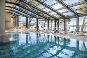 a pool with chairs and a person in the water at Grand Hotel Bernardin in Portorož