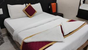 a large bed with white sheets and pillows at RK Residency in Tirupati