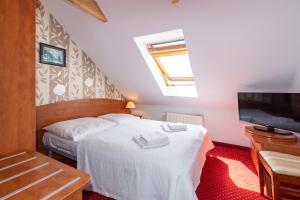 a bedroom with two beds and a flat screen tv at Bałtyk Resort in Rewal