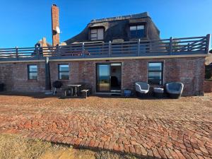 a brick house with a balcony on top of it at Pervinca al Mare in Stilbaai +5 photos