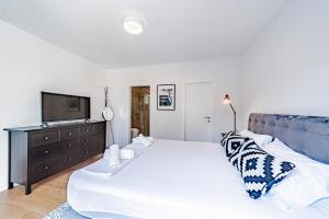 a bedroom with a large bed and a television at Sunset Luxury Beach Apartment - Private Pool in Ivan Dolac