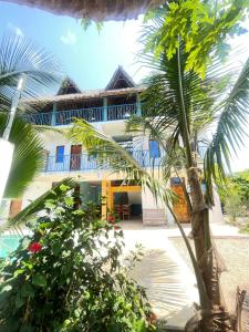 ein Haus mit einer Palme davor in der Unterkunft Sabali Lodge, Zanzibar in Jambiani
