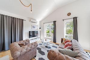 a living room with two couches and a tv at Sunset Luxury Beach Apartment - Private Pool in Ivan Dolac