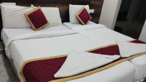 two beds with white sheets and pillows at RK Residency in Tirupati