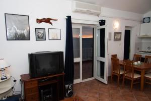 a living room with a television and a dining room at Apartments Sundance in Okrug Donji