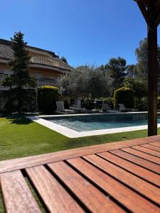 a wooden bench sitting next to a swimming pool at Carrasca 8 paddle & pool in Alcoy
