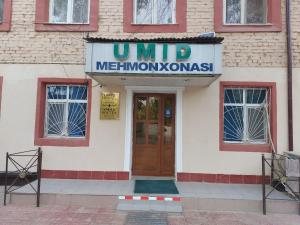 a sign on the front of a building with a door at Umid Hostel in Termiz