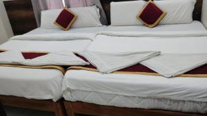 a group of three twin beds sitting next to each other at RK Residency in Tirupati +1 photo