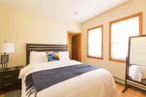 a bedroom with a large bed and two windows at 1 Bedroom Apartments Near Kendall Square in Cambridge