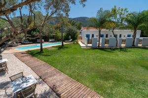 a yard with a swimming pool and a house at Boho Suites Denia in Denia
