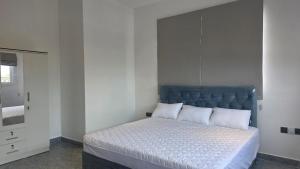 a bedroom with a large bed with a blue headboard at The Harmony Mount Lavinia in Dehiwala