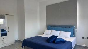 a bedroom with a blue and white bed with blue pillows at The Harmony Mount Lavinia in Dehiwala +9 photos