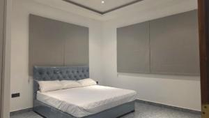 a bedroom with a bed with a gray headboard at The Harmony Mount Lavinia in Dehiwala