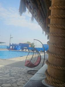 a basket chair sitting next to a swimming pool at NectaraVilla PooL in Ashtarak +17 photos
