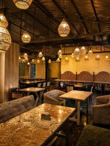 a restaurant with tables and chairs and chandeliers at The Zinnia Castle- Dharamshala # Centrally Heated & Air Cooled # Premium Rooms # Lift # Bar # Terrace # Big Parking # Near market # Top Rated # Property of the year in Dharamshala