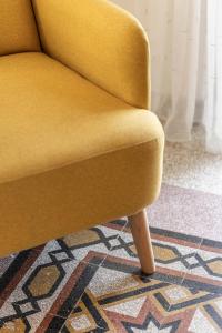 a yellow chair sitting on top of a rug at TorripaCollection - Villa Livia - Bolsena Lake in Montefiascone