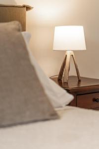 a bedside table with a lamp on a bed at TorripaCollection - Villa Livia - Bolsena Lake in Montefiascone