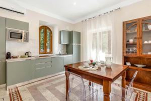 a kitchen with a wooden table and a kitchen with green cabinets at TorripaCollection - Villa Livia - Bolsena Lake in Montefiascone +39 photos