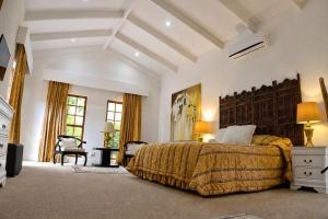 a bedroom with a king sized bed and a chair at Val d'Or Estate in Franschhoek +77 photos