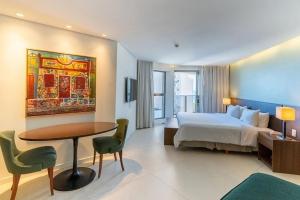 a bedroom with a bed and a desk and a table at HY BEACH FLATS - INTERNATIONAL in Recife +21 photos