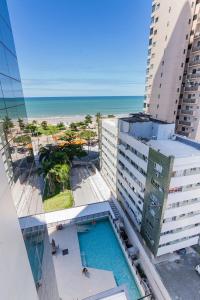 a view of a building with a swimming pool and the ocean at HY BEACH FLATS - INTERNATIONAL in Recife