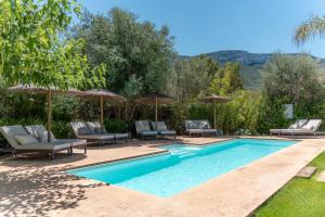 a swimming pool with lounge chairs and umbrellas at Boho Suites Denia in Denia