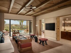 a living room with a couch and a tv at Six Senses AMAALA in Amala