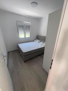 a small bedroom with a bed and a window at Rujovic 