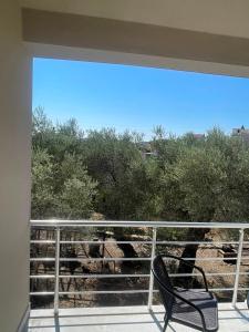 a chair sitting on a balcony with a view of trees at Rujovic 