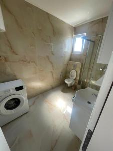 a bathroom with a washing machine and a toilet at Rujovic 