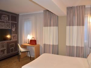 a bedroom with a bed and a chair and a desk at ibis Melun in Melun