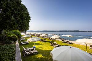 a group of umbrellas and lounge chairs and a beach at Grand Hotel Bernardin in Portorož