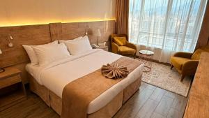 a hotel room with a large bed and a large window at Emaar Legend in Mecca +21 photos