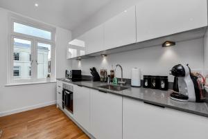 a kitchen with white walls and a counter top at Newly Reopened, Modern Flat Central Location in Staines +12 photos
