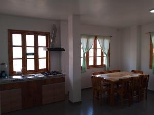 a kitchen with a table and chairs and a kitchen with windows at Fifi Shouse Ayangue in Santa Elena