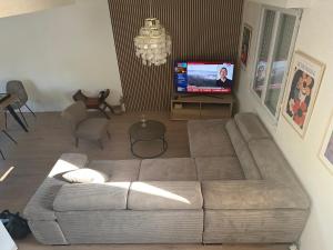 a living room with a couch and a tv at Maison de Corinne in Sarzeau
