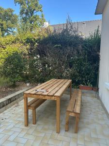 a wooden bench sitting on top of a patio at Maison de Corinne in Sarzeau