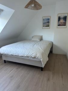 a bedroom with a bed in a white room at Maison de Corinne in Sarzeau