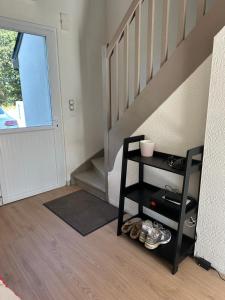 a room with a staircase and a shelf with shoes at Maison de Corinne in Sarzeau +1 photo