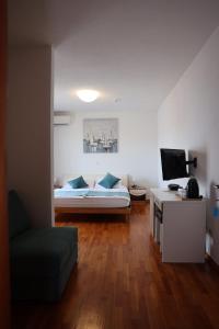 a bedroom with a bed and a desk with a television at Villa Ljubica in Pakoštane