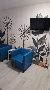 a living room with two blue couches and a wall at Art Rock Airport in Cologne