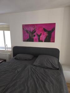 a painting of three deer on a wall above a bed at Zimmer im Oldenburger Dobbenviertel in Oldenburg