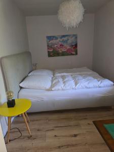 a bed in a room with a yellow table at Zimmer im Oldenburger Dobbenviertel in Oldenburg