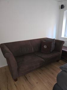 a brown leather couch in a living room at Zimmer im Oldenburger Dobbenviertel in Oldenburg