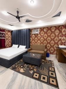 a bedroom with a bed and a couch and a table at Hotel Parinay Vatika in Deoghar