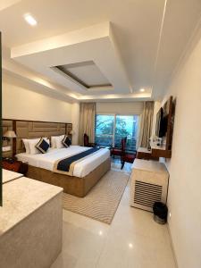a hotel room with a bed and a large window at The Zinnia Castle- Dharamshala # Centrally Heated & Air Cooled # Premium Rooms # Lift # Bar # Terrace # Big Parking # Near market # Top Rated # Property of the year in Dharamshala +108 photos